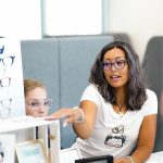A photo of a woman at a booth with glasses