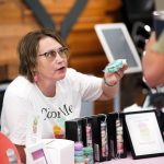 A photo of a woman at a booth with macarons