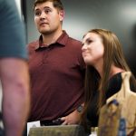 A photo of a man and woman listening