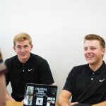 A photo of two men at a booth for celestial bags