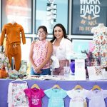 A photo of two girls posing at a booth for girl clothes