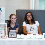 A photo of two girls posing at a booth for glasses