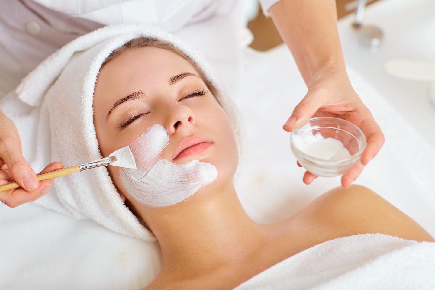 Photograph of a Woman getting facial treatment at a spa.