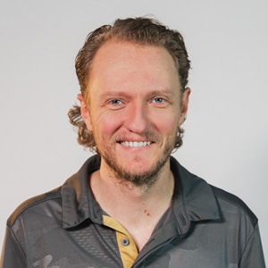 Shad Esplin smiling in a gray polo shirt against a light background.